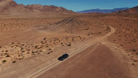 Driving-a-modern-black-car-on-desert-dirt-road-off-road-in-Nevada-close-to-Death-Valley