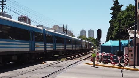 Öffentlicher-Zug-In-Zeitlupe-überquert-Gleise,-Sicherheitsbeamter-Arbeitet,-Mann-Im-Rollstuhl-Sarmiento-Linie