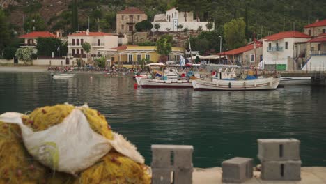Medium-establishing-view-of-Leonidio-Greece-harbor-with-boats-anchored-and-Mediterranean-homes-on-hillside