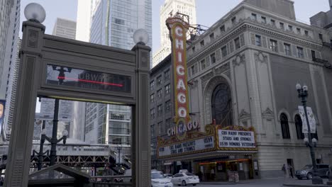 Iconic-Chicago-Theater-marquee-sign-with-bustling-street-activity-and-elevated-train-tracks-in-the-background