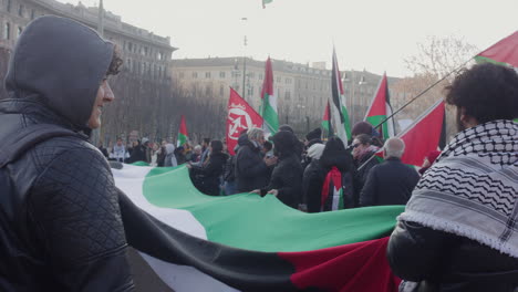Manifestant-stand-with-flag-close-to-castello-sforzesco,-Milan-asking-for-freeing-Palestina