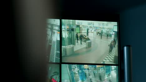Multi-screen-security-footage-of-a-train-station-with-passengers-and-staff,-conveying-a-sense-of-surveillance