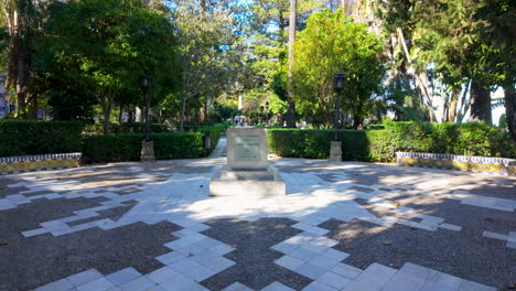 park-with-a-checkered-pathway-leading-up-to-a-central-monument-or-plaque-on-a-pedestal