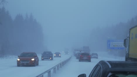 Too-strong-a-blizzard-on-the-right-side-of-the-road,-cars-are-stuck-in-a-traffic-jam,-on-the-left-side-of-the-road,-cars-move-through-snow