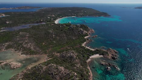 aerial-drone-approaching-video-of-panoramic-landscape-in-sardinia,-italy-with-particular-rocky-geography-of-volcanic-origin-and-turquoise-and-emerald-Mediterranean-sea