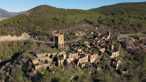 Drohne-Umkreist-Die-Mittelalterliche-Burg-Des-Verlassenen-Dorfes-Ruesta,-Spanien