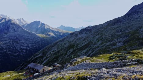 Fly-by-drone-shot-beautiful-scenic-view-of-European-hut-named-"Olpererhütte"-in-Austrian-Alps-in-summer-with-the-Schlegeis-Stausee-below