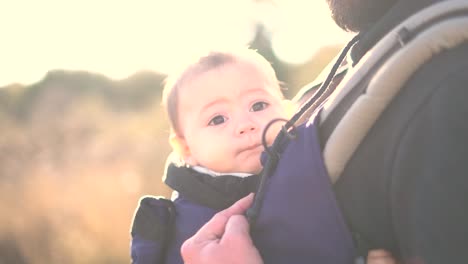 Murcia,-Spain,-January-16,-2024:-Cute-little-baby-being-carried-on-his-father-arms-while-taking-a-walk-through-nature-at-sunrise