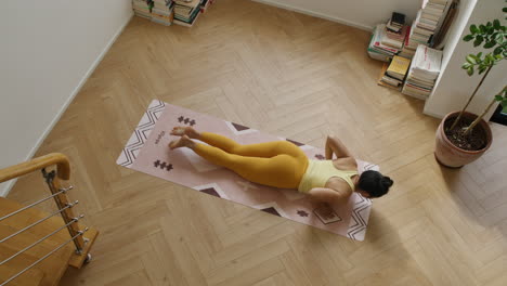 Top-down-view-of-young-athletic-fit-Asian-woman-practicing-yoga-san-salutation-in-her-apartment-room,-mind-and-body-training,-healthy-lifestyle