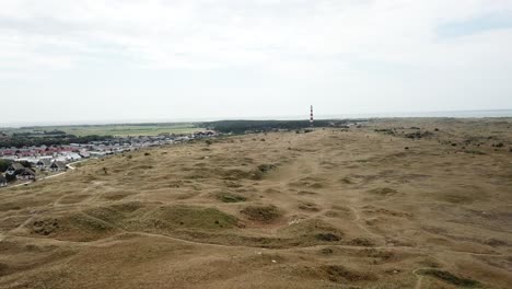 Aerial-view-of-Ameland-Island-featuring-a-campsite-and-iconic-lighthouse