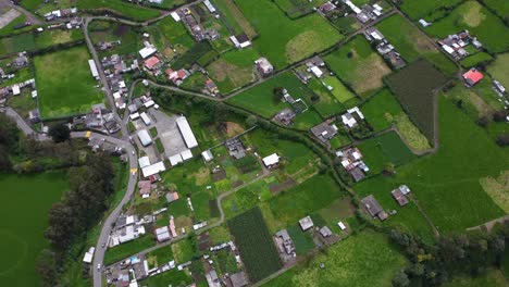 Aerial-over-rural-homesteads-Ecuador-vibrant-green-arable-farmland-DRONE