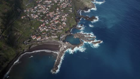 Aerial-top-shot-with-drone-of-a-serene-coastal-town-with-a-natural-lagoon-at-Seixal,-Madeira