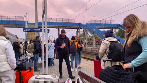 Ukrainian-refugees-waiting-for-a-train-to-arrive-at-the-Chelm-train-station-in-Poland,-people-fleeing-and-escaping-war,-4K-shot