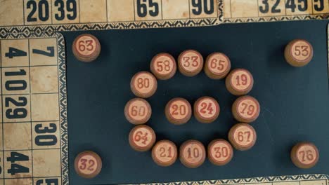 Cinematic-close-up-smooth-tilt-down,-shot-from-above-of-a-Bingo-wooden-barrels-in-a-circle,-woody-figures,-old-numbers-background,-vintage-board-game,-professional-lighting,-slow-motion-120-fps