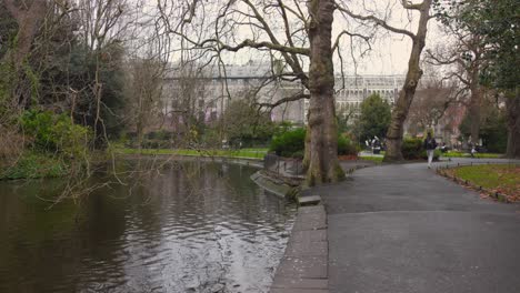 Shot-of-a-pond-beside-a-pathway-on-which-people-walking-at-St