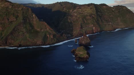 Vista-Aérea-Con-Drones-De-Acantilados-Escarpados-Y-Rocas-Aisladas-En-El-Océano-Durante-La-Hora-Dorada