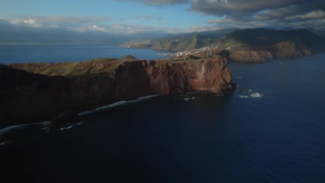 Aerial-view-of-rugged-cliffs-beside-calm-ocean-waters