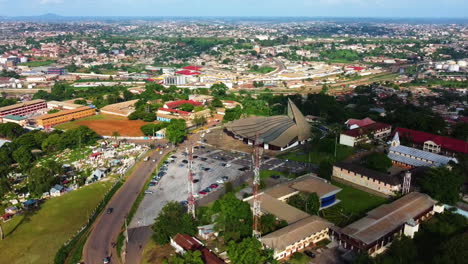 Aerial-view-of-traffic-on-the-streets-in-front-of-the-Basilica-of-Mary-Queen-of-Apostles,-in-sunny-Yaounde,-Cameroon
