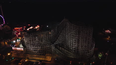 Drone-shot-circling-the-rollercoaster-at-the-Kemah-Boardwalk,-night-in-Texas,-USA