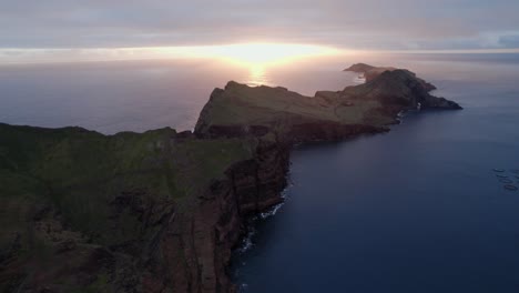Drohne,-Die-Bei-Sonnenaufgang-über-Dem-Meer-Fliegt-Und-Die-Malerische-Meeresküste-Mit-Klippen-Bei-Einem-Lebendigen-Sonnenuntergang-Betrachtet
