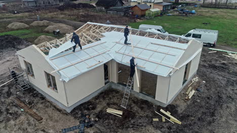 Aerial-view-of-workers-on-a-house-frame-at-a-construction-site-during-the-day