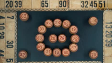 Cinematic-close-up-smooth-zoom-in,-shot-from-above-of-a-Bingo-wooden-barrels-in-a-circle,-woody-figures,-old-numbers-background,-vintage-board-game,-professional-lighting,-slow-motion-120-fps