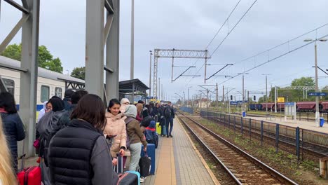 Refugiados-Ucranianos-Esperando-Que-Llegue-Un-Tren-A-La-Estación-De-Tren-De-Chelm-En-Polonia,-Personas-Que-Huyen-Y-Escapan-De-La-Guerra,-Días-Nublados,-Tomas-De-4k