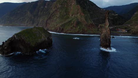 Drone-orbiting-around-an-ocean-rock-over-the-sea-at-sunrise-on-the-seaside-at-Madeira