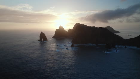 Drohne-Fliegt-Bei-Sonnenuntergang-über-Dem-Blauen-Ozean-An-Der-Zerklüfteten-Küste-Von-Madeira