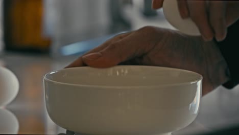 Man-cracking-an-egg-on-the-edge-of-a-white-bowl