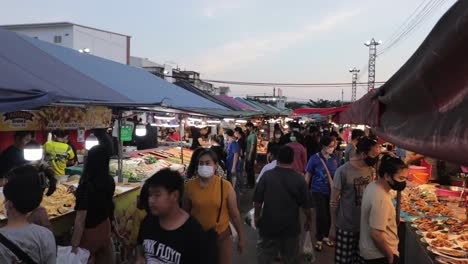 Crowd-Of-People-Walking-Through-Food-Stalls-At-Night-Market-At-Dusk-In-Rayong,-Thailand