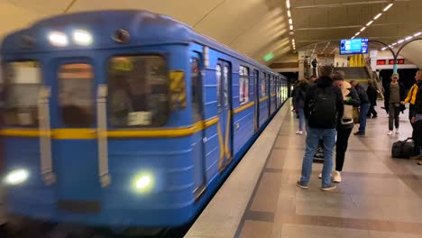 People-taking-the-arriving-underground-subway-metro-tube-in-Kyiv-Ukraine,-quick-transportation-around-a-city,-4K-shot