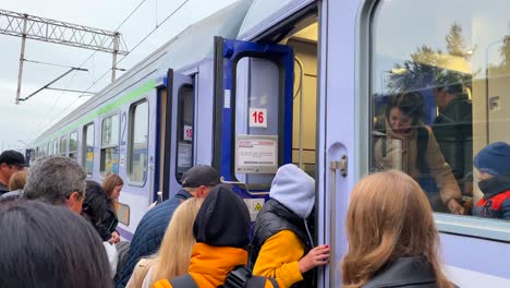 Ukrainian-refugees-boarding-the-Chelm-to-Warsaw-train-at-the-Chelm-train-station-in-Poland,-people-fleeing-and-escaping-war,-4K-shot