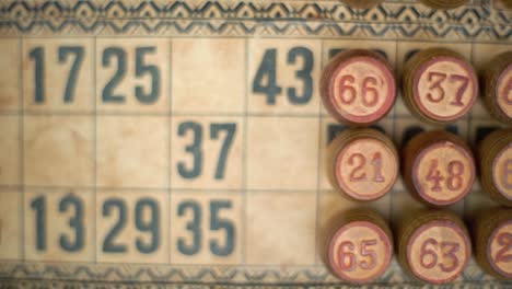 Cinematic-close-up-smooth-pan-right-shot-of-a-Bingo-wooden-barrels,-woody-figures,-on-a-old-numbers-textured-background,-vintage-board-game,-lucky-number,-professional-lighting,-slow-motion-120-fps