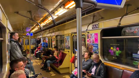 People-sitting-and-riding-the-underground-subway-metro-tube-in-Kyiv-Ukraine,-quick-transportation-around-a-city,-people-going-places,-4K-shot