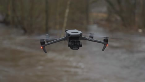 Drohne-Schwebt-Und-Bleibt-Bei-Windigen-Bedingungen-über-Dem-überfluteten-Herbstfluss-Stabil