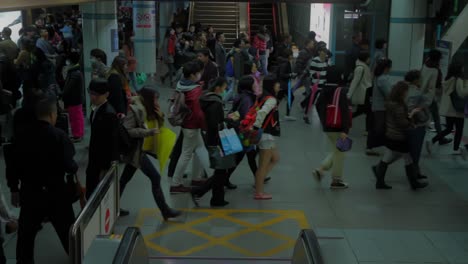 Immense-mass-of-asian-people-and-commuters-appear-during-cinematic-descent-from-escalator