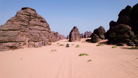 Vehículo-Del-Desierto-Conduciendo-Sobre-Dunas-De-Arena-A-Través-De-Formaciones-De-Arenisca-En-El-Parque-Nacional-Tassili-N&#39;ajjer-En-Argelia