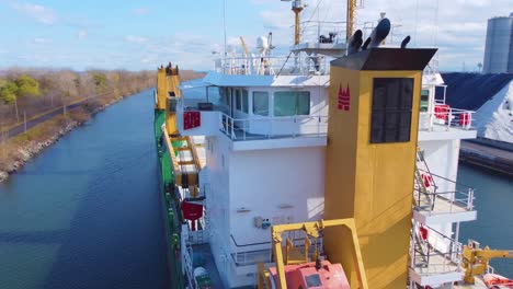 Drone-flyover-a-large-tanker-cargo-ship-in-Montréal-water-canal,-Canada