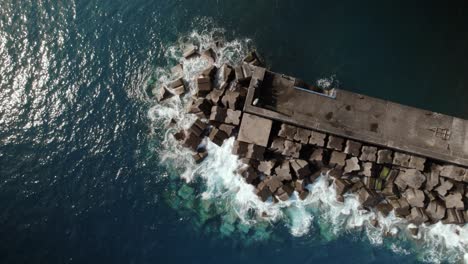 Aerial-drone-top-shot-of-sea-defense-breakwater-with-crashing-waves