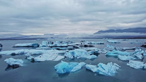 Crane-down-drone-shot-of-iceberg-in-Jökulsárlón-the-glacier-lagoon-in-Iceland