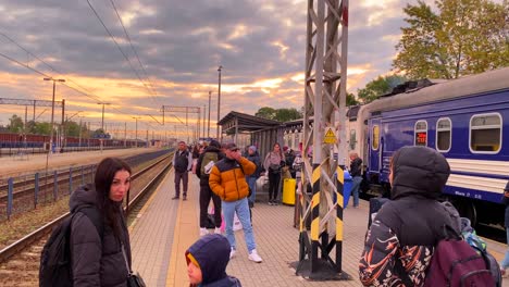Ukrainian-refugees-waiting-for-the-Chelm-to-Warsaw-train-early-morning-at-the-Chelm-train-station-in-Poland,-people-fleeing-and-escaping-war,-Ukrainian-Railways-Ukrzaliznycia-train,-4K-shot