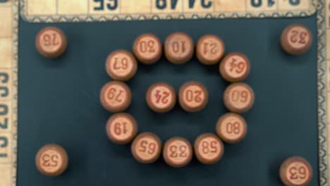 Cinematic-close-up-smooth-zoom-in-shot-from-above-of-a-Bingo-wooden-barrels-in-a-circle,-woody-figures,-old-numbers-background,-vintage-board-game,-professional-lighting,-slow-motion-4K-video