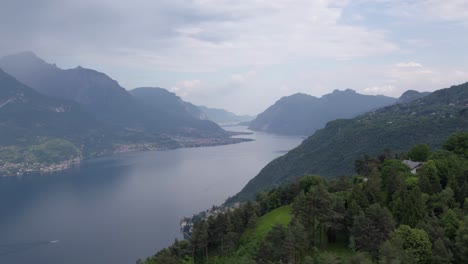 Paralaje-Del-Lago-Como-Rodeado-De-Montañas-Boscosas-Y-Pequeños-Pueblos