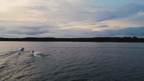 Waterski-near-Stockholm-on-sunny-summer-evening,-aerial-follow-view