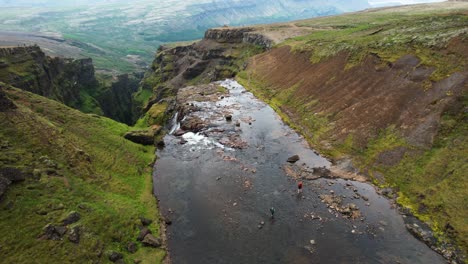 Glymur-waterfalls-falling-into-deep-valley-in-Iceland,-aerial-top-down-view