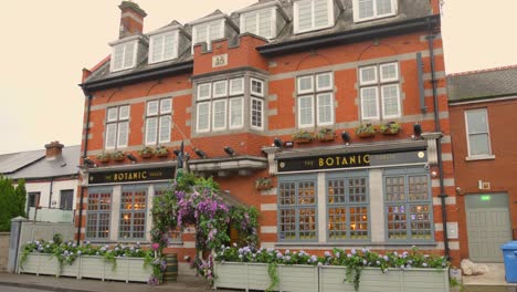 Famous-brick-facade-with-flower-garlands-of-The-Botanic-pub-in-Dublin
