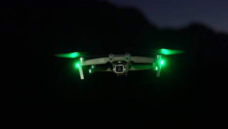 DJI-Air-2S-drone-flying-at-night-with-green-safety-lights,-professional-camera-drone
