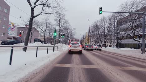 POV-Car-in-Traffic-Snowy-City-Roads,-Finland