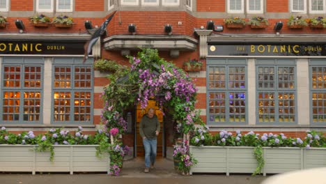 Two-men-leaving-famous-Dublin-The-Botanic-pub-with-flower-garland-door
